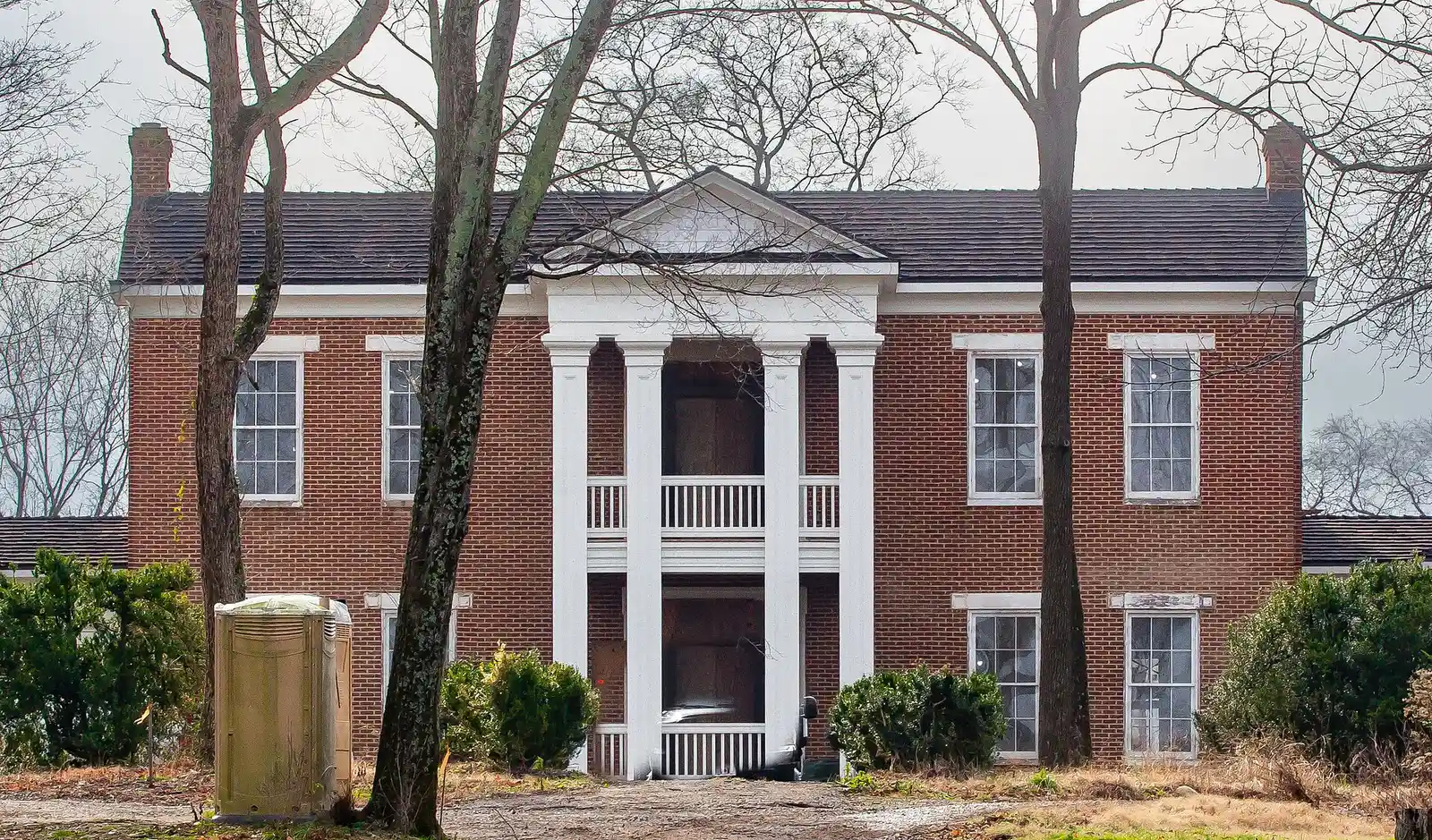 The Thomas Holt House in Brentwood, a two-story brick house with a columned portico, during renovation work